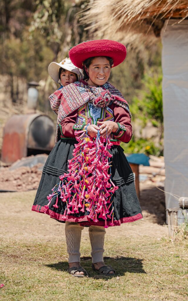A woman from the Ccorcor community near Cusco with her child and flower garlands