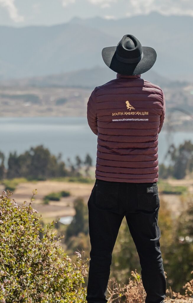 A South American Luxe guide looking out over a lake and the Andes near Cusco
